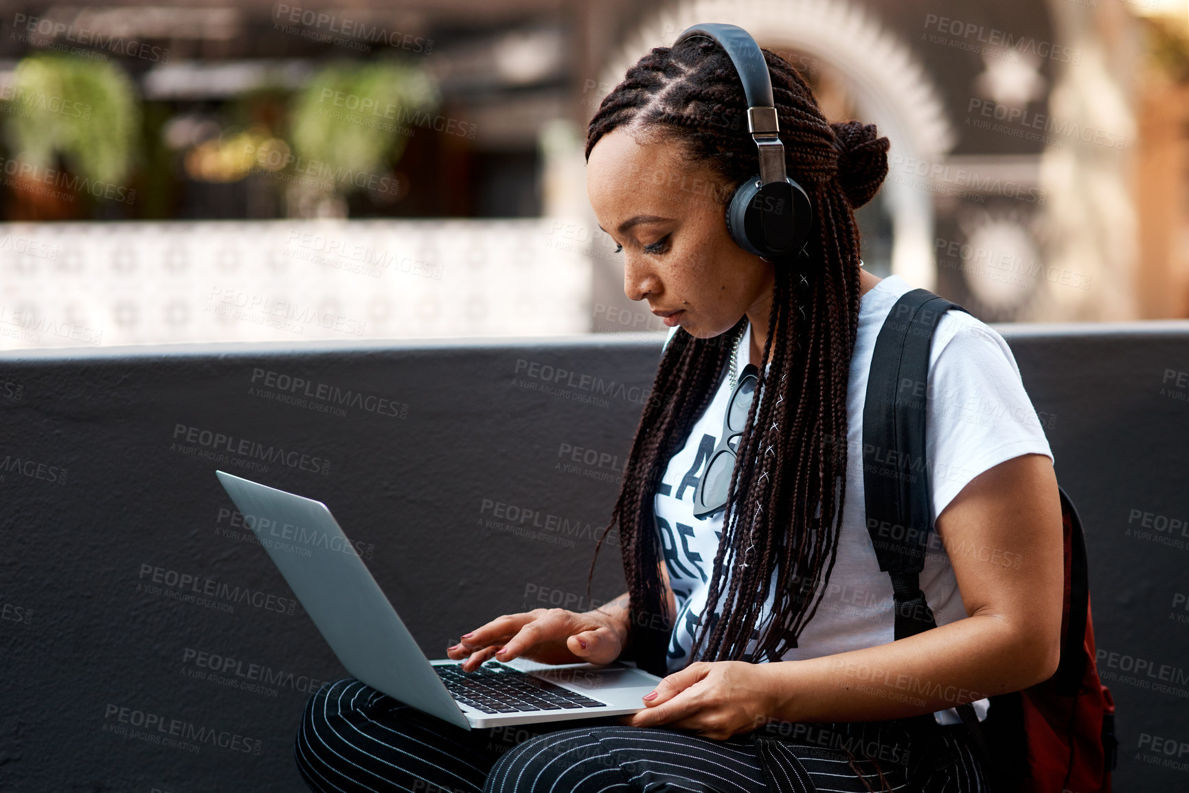 Buy stock photo Woman, student and headset with laptop outside, typing and online classes for elearning or education. University, leaner and website research for assignment, listening and podcast or school project