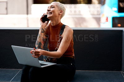 Buy stock photo Shot of an attractive young woman using her laptop while making a phone call outdoors
