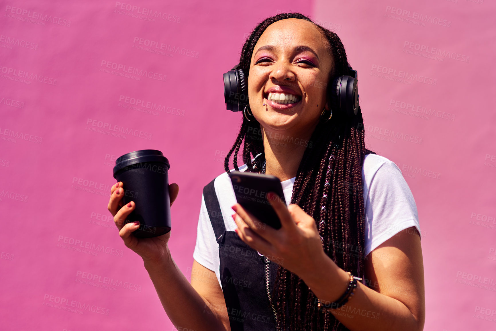 Buy stock photo Woman, phone and outdoor for audio or coffee, streaming sound and subscription by pink background. Female person, latte and listen to podcast or online for social media, laughing and travel in city