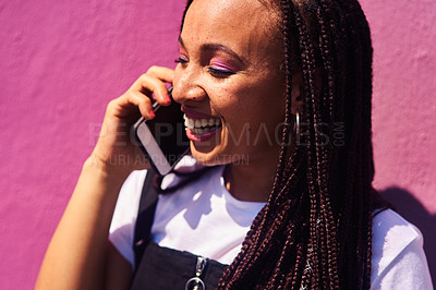 Buy stock photo Cropped shot of an attractive young woman standing against a pink wall alone and talking on her cellphone