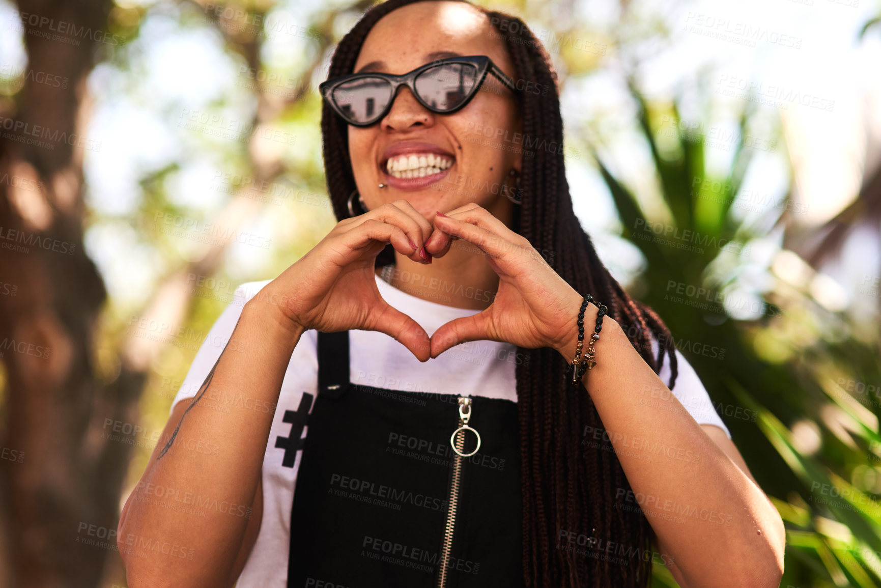 Buy stock photo African woman, student and outdoor with heart hands, summer and sunglasses in park with love in sunshine. Girl, person and smile with symbol, kindness and icon with choice on vacation in urban garden