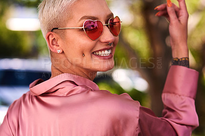 Buy stock photo Closeup portrait of an attractive and stylish young woman wearing sunglasses relaxing in a park outdoors