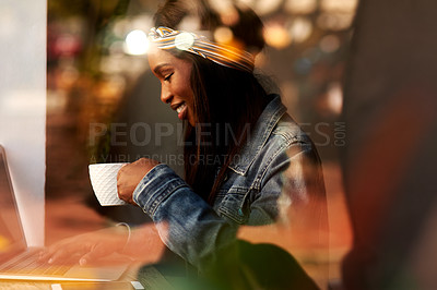 Buy stock photo Shot of an attractive young woman drinking coffee and using a laptop while relaxing inside a local cafe