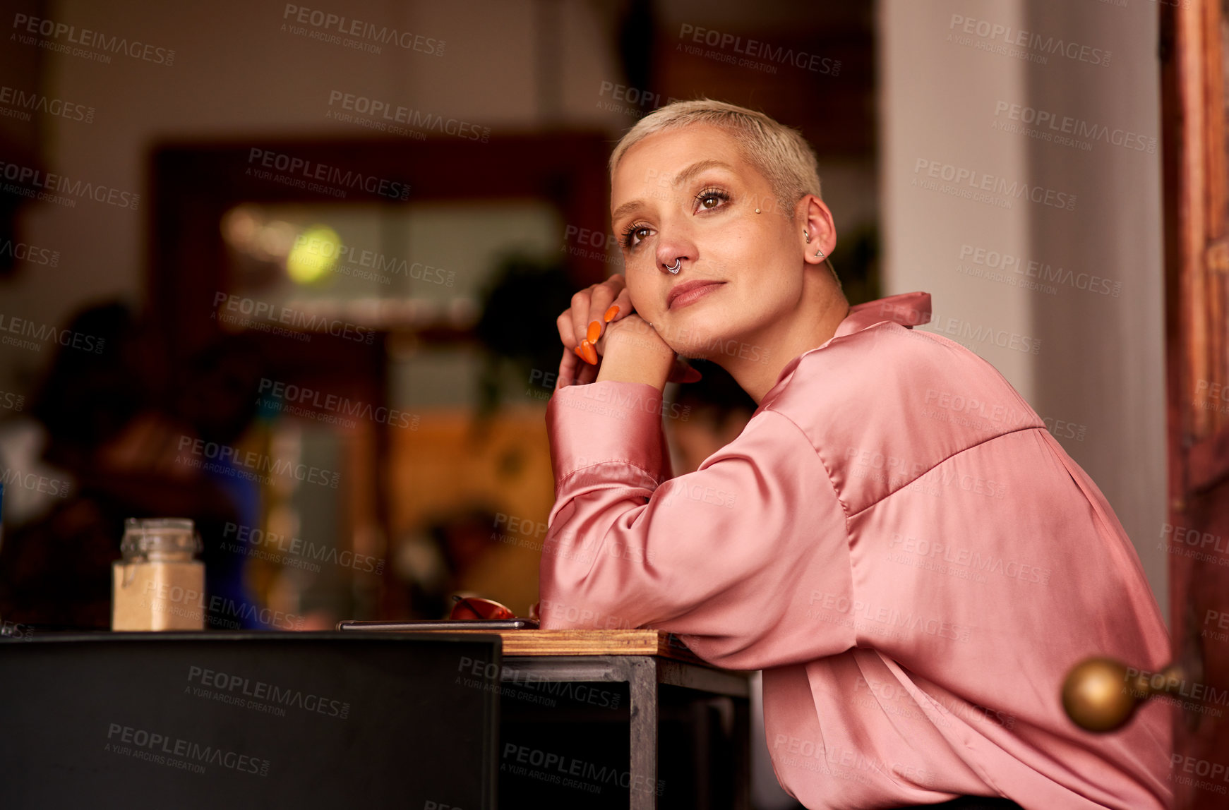 Buy stock photo Shot of an attractive young woman looking thoughtful while relaxing inside a cafe