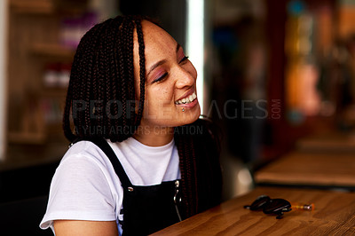 Buy stock photo Shot of an attractive and happy young woman relaxing inside a local cafe