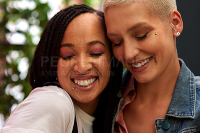 Buy stock photo Shot of two attractive young women hanging out and spending time together outdoors