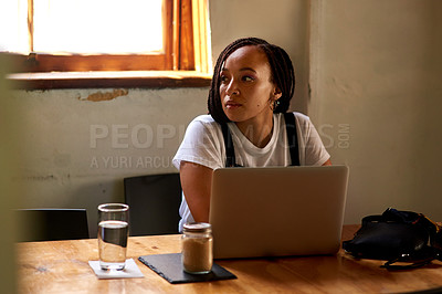 Buy stock photo Shot of an attractive young woman using her laptop while relaxing inside a local cafe
