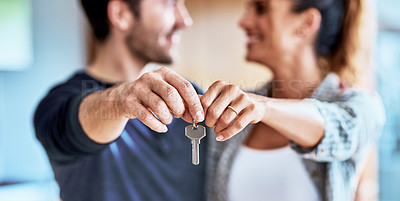 Buy stock photo Cropped shot of an unrecognizable couple holding up the key to their new home indoors