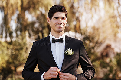 Buy stock photo Cropped shot of a handsome young bridegroom adjusting his suit while preparing for his wedding outdoors