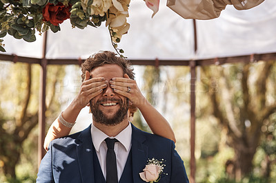 Buy stock photo Cropped shot of an unrecognizable bride covering her groom's eyes from behind while standing outdoors on their wedding day
