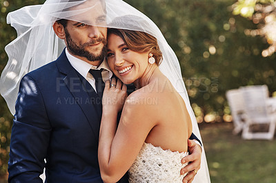 Buy stock photo Cropped shot of an affectionate young bride smiling embracing her groom under a veil on their wedding day