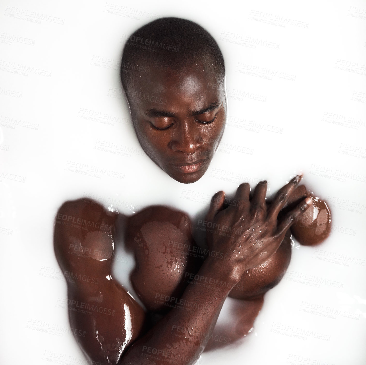 Buy stock photo Shot of a muscular young man having a milky bath at home