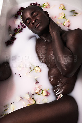 Buy stock photo Cropped shot of a muscular young man having a milky bath filled with flowers at home