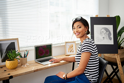 Buy stock photo Portrait of an attractive young artist using a laptop while working inside her studio at home