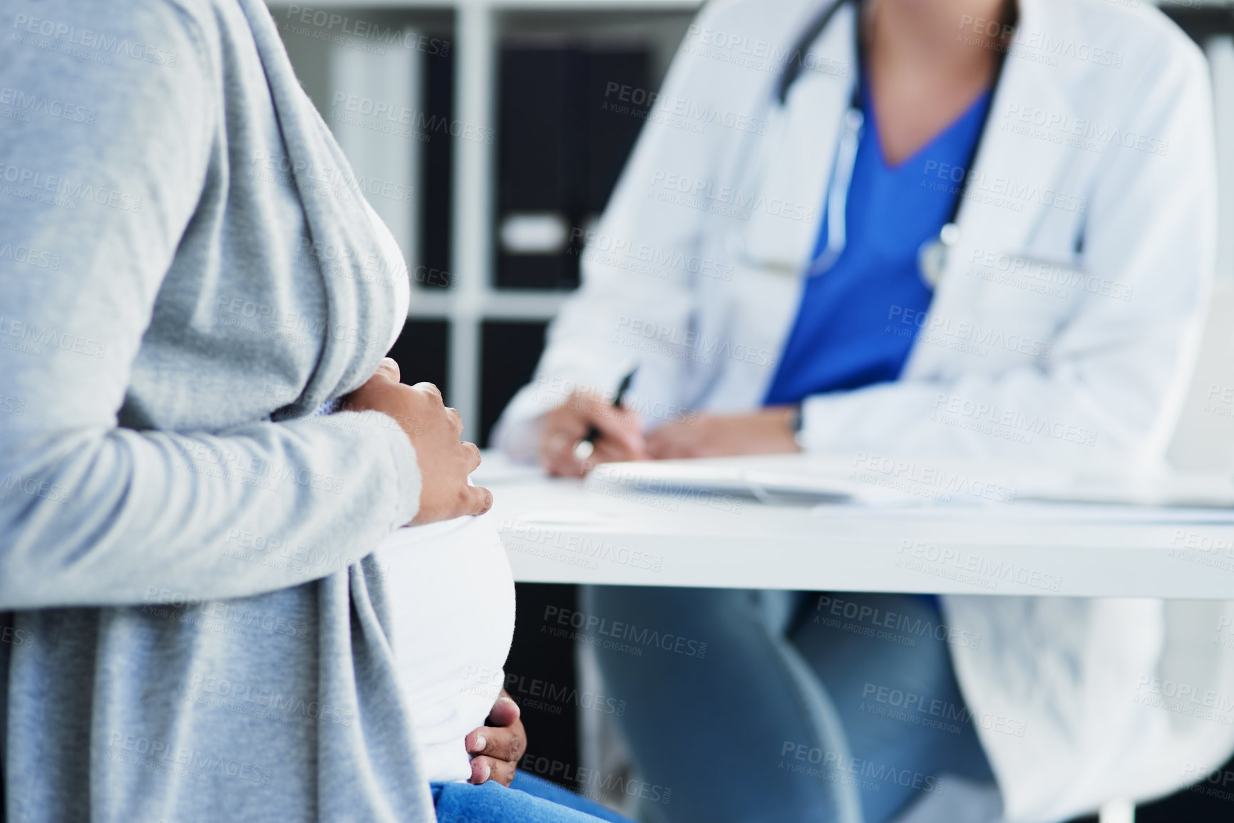 Buy stock photo Cropped shot of an unrecognizable female doctor consulting with a pregnant patient at a hospital during the day