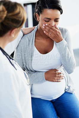 Buy stock photo Cropped shot of a young female doctor trying to comfort a distressed pregnant patient at a hospital during the day