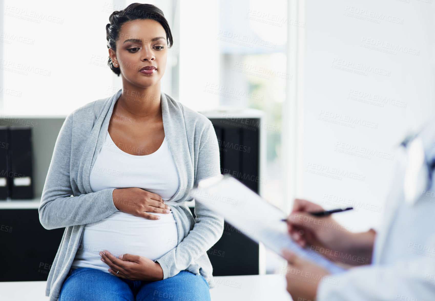 Buy stock photo Cropped shot of an unrecognizable female doctor consulting with a pregnant patient at a hospital during the day