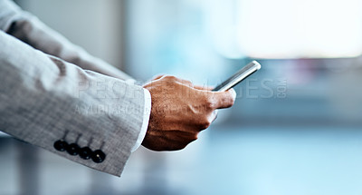 Buy stock photo Cropped shot of an unrecognizable businessman standing alone in his office and using his cellphone