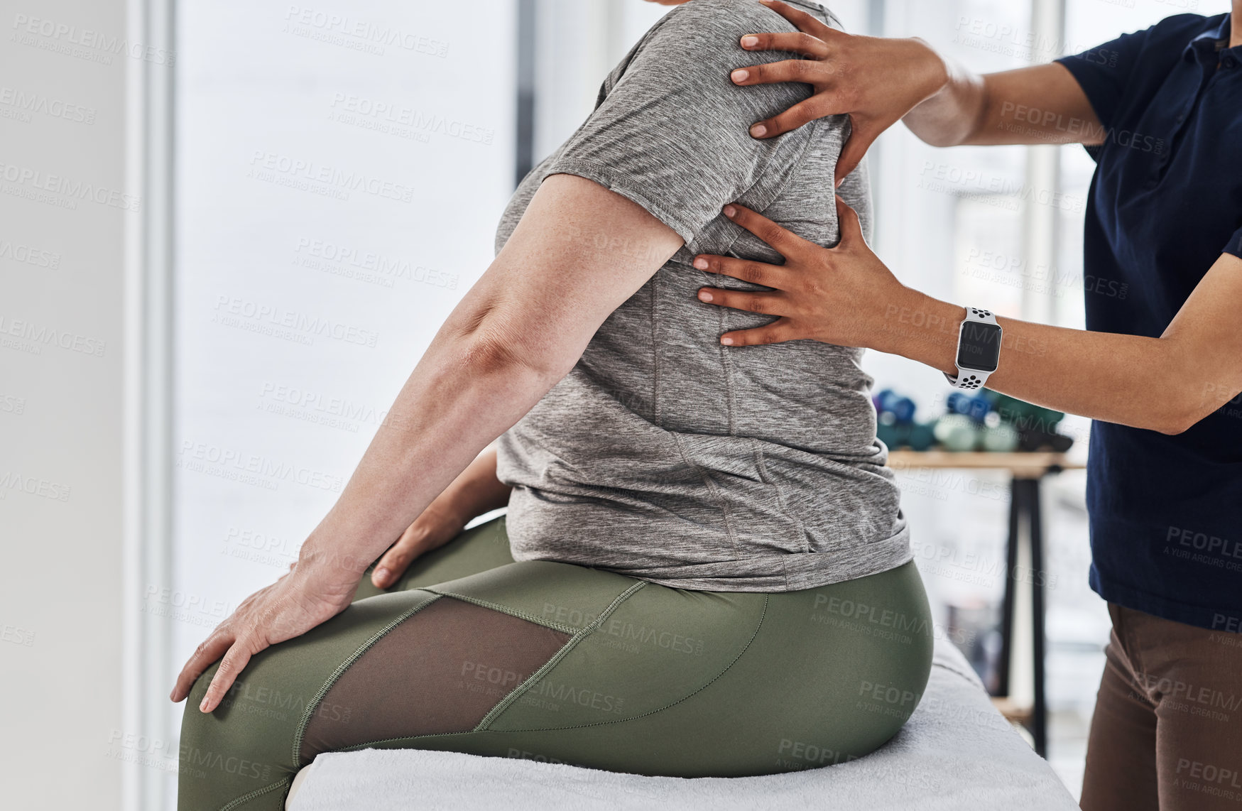 Buy stock photo Shot of an unrecognizable woman getting her back examined by a physiotherapist at a clinic