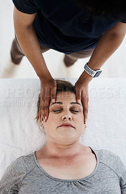 Buy stock photo Shot of a mature woman getting her head and neck treated by a physiotherapist at a clinic