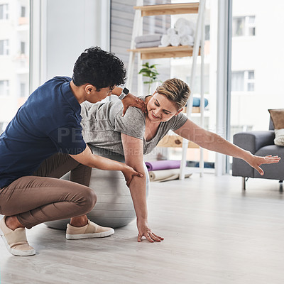 Buy stock photo Shot of a mature woman doing balance and movement exercises with her physiotherapist at a rehabilitation centre