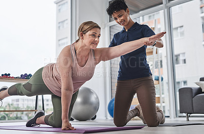 Buy stock photo Full length shot of a mature woman doing rehabilitation and movement exercises with her physiotherapist at a clinic