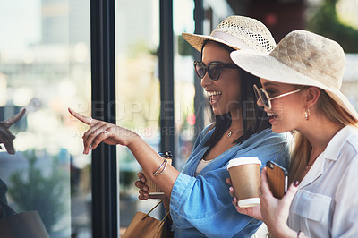 Buy stock photo Cropped shot of two attractive young girlfriends window shopping together in the city during the day