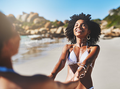 Buy stock photo Shot of two young women enjoying a playful moment on the beach