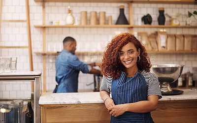 Buy stock photo Cropped shot of an attractive young businesswoman standing in her cafe while a barista works behind her