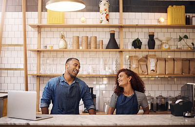 Buy stock photo Cropped shot of two young business owners standing in their cafe and looking at each other