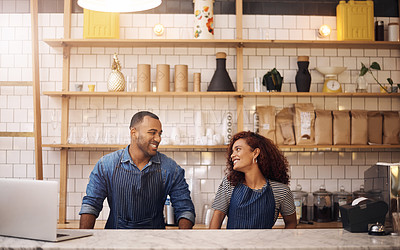 Buy stock photo Cropped shot of two young business owners standing in their cafe and looking at each other
