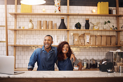 Buy stock photo Cropped shot of two young business owners standing in their cafe with their arms around each other