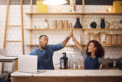 Buy stock photo Cropped shot of two young business owners standing in their cafe together and giving each other a high five