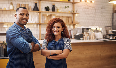 Buy stock photo Cropped shot of two young business owners standing in their cafe together with their arms folded
