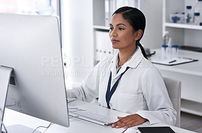 Buy stock photo Cropped shot of an attractive young female scientist working on her computer in the laboratory