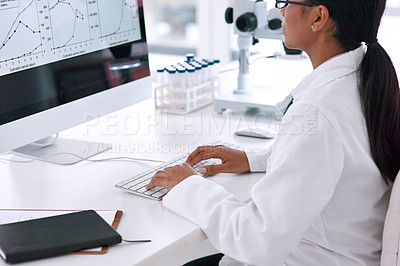 Buy stock photo Cropped shot of an unrecognizable young female scientist working on her computer in the laboratory