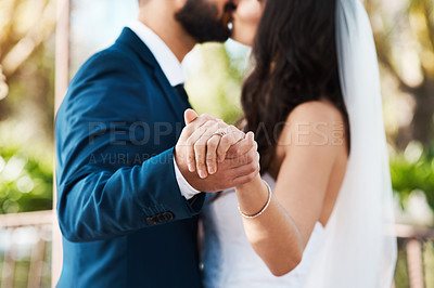 Buy stock photo Couple, kiss and holding hands at wedding in dance with love or celebration of marriage. Engagement, diamond ring and man with commitment to bride at event with trust, loyalty and respect for partner