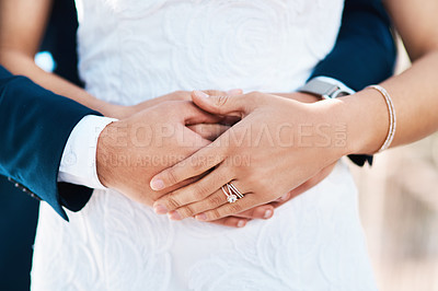 Buy stock photo Cropped shot of an unrecognizable bridegroom embracing his bride from behind while standing outdoors on their wedding day