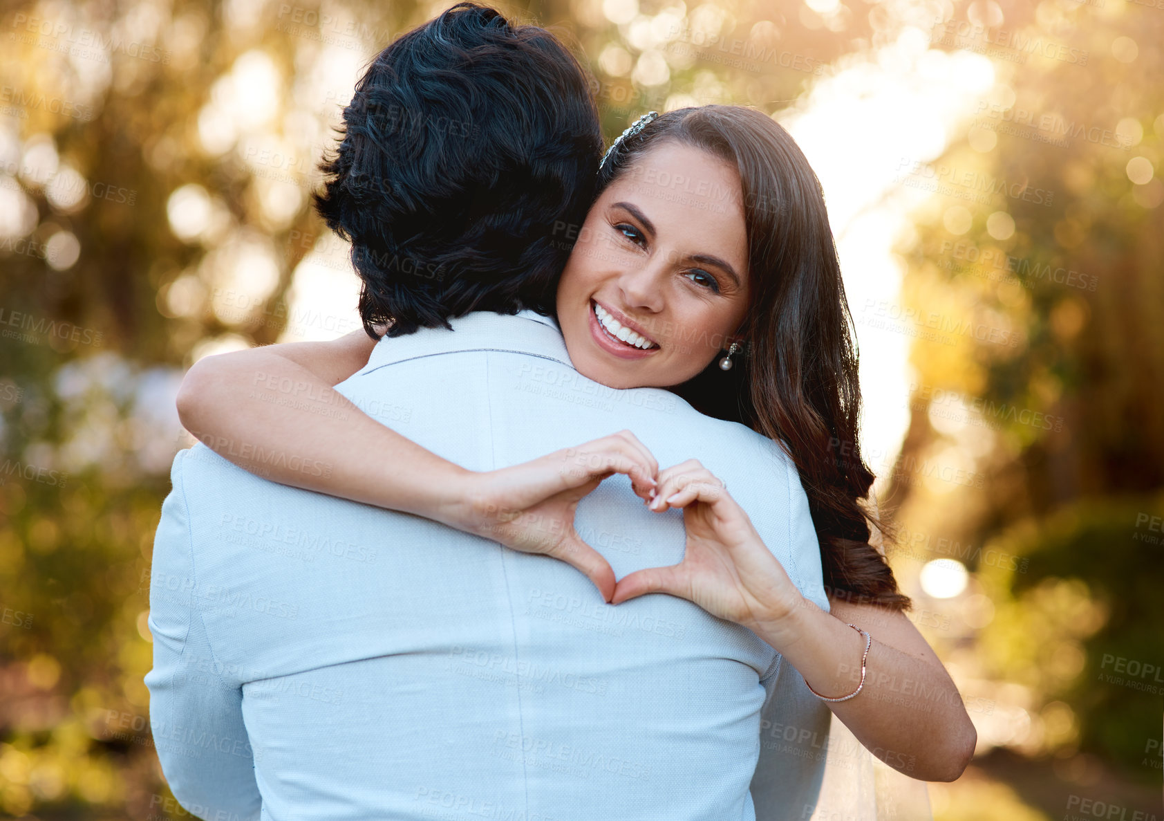 Buy stock photo Couple, hug and heart hand gesture in nature for happy, romance and anniversary in garden. Woman, man and love shape in portrait for date, loyalty or commitment in park for valentines day and outdoor