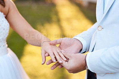 Buy stock photo Cropped shot of a bridegroom putting a ring on his bride's finger