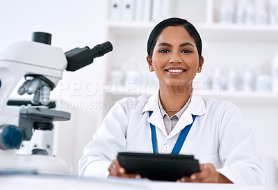 Buy stock photo Cropped portrait of an attractive young female scientist smiling while holding a digital tablet in a laboratory