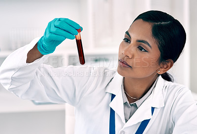 Buy stock photo Cropped shot of an attractive young female scientist  inspecting a test tube filled with blood while working in a laboratory