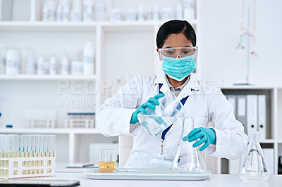 Buy stock photo Cropped shot of an attractive young female scientist transferring a clear liquid from a beaker to a conical flask while working in a laboratory