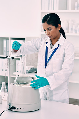 Buy stock photo Cropped shot of an attractive young female scientist working with a centrifuge and a conical flask in a laboratory