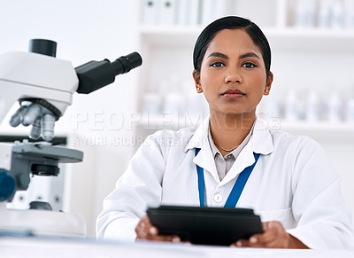 Buy stock photo Cropped portrait of an attractive young female scientist using a digital tablet while working in a laboratory