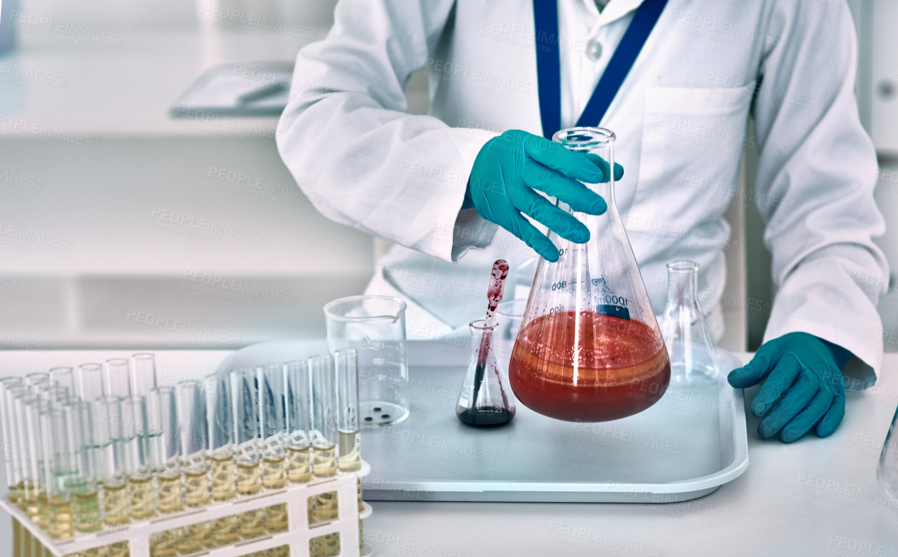 Buy stock photo Cropped shot of an unrecognizable female scientist conducting an experiment with a red liquid in a laboratory
