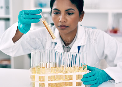 Buy stock photo Cropped shot of an attractive young female scientist conducting an experiment with a tray of test tubes in a laboratory