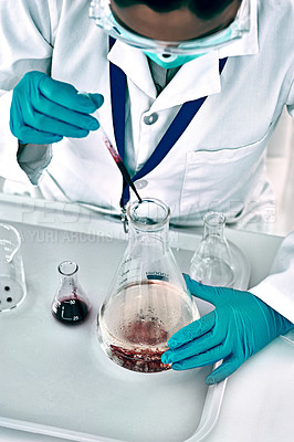 Buy stock photo High angle shot of an unrecognizable female scientist conducting an experiment with a liquid in a laboratory