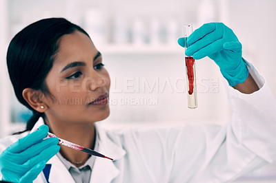 Buy stock photo Cropped shot of an attractive young female scientist inspecting a blood sample in a test tube while working in a laboratory