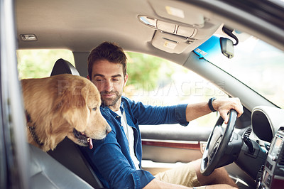 Buy stock photo Cropped shot of a handsome young man sitting in the car with his golden retriever during a road trip